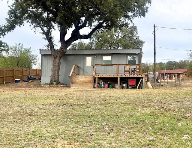 back of house with a deck and a lawn