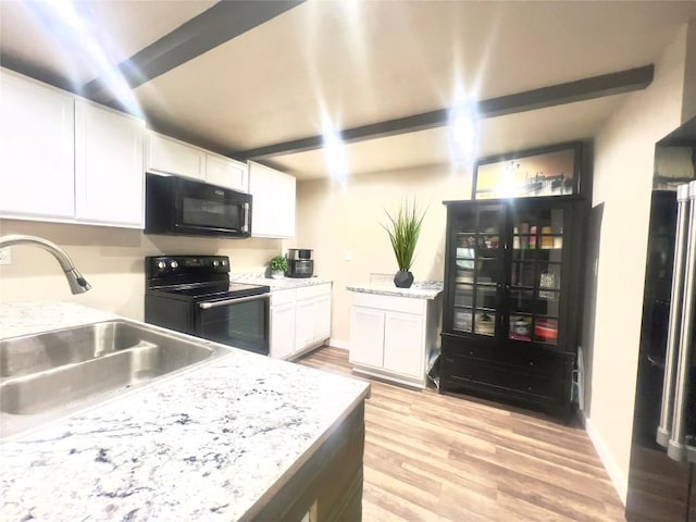 kitchen featuring black appliances, white cabinets, sink, light wood-type flooring, and light stone counters