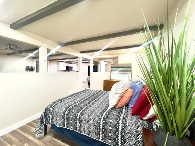 bedroom with beamed ceiling and hardwood / wood-style flooring