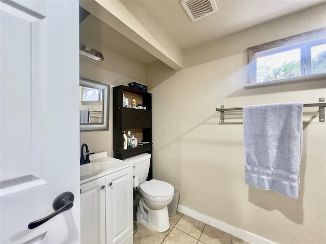 bathroom with toilet, plenty of natural light, vanity, and tile patterned flooring