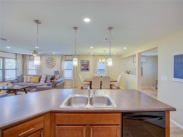 kitchen featuring dishwasher, decorative light fixtures, light tile patterned flooring, and sink