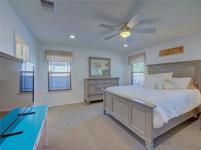 carpeted bedroom featuring multiple windows and ceiling fan