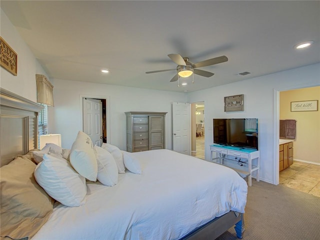 bedroom with light carpet, connected bathroom, and ceiling fan