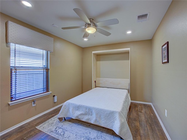 bedroom featuring a closet, dark hardwood / wood-style floors, and ceiling fan