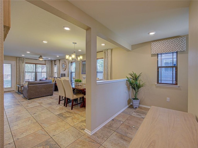 dining space with ceiling fan with notable chandelier