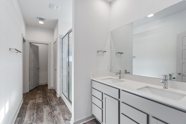 bathroom featuring wood-type flooring, vanity, and a shower with shower door