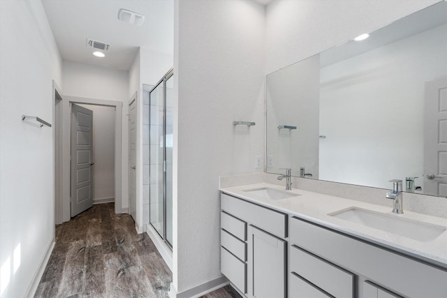 10400 Fulton Ave, Austin, TX 78754 - bathroom with a shower stall, double vanity, wood finished floors, and baseboards