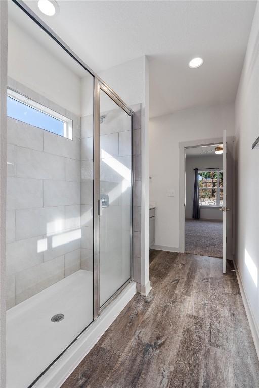 bathroom featuring vanity, hardwood / wood-style flooring, and a shower with door