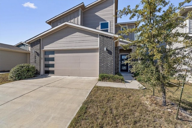 10400 Fulton Ave, Austin, TX 78754 - view of front facade featuring brick siding, driveway, a garage, and board and batten siding