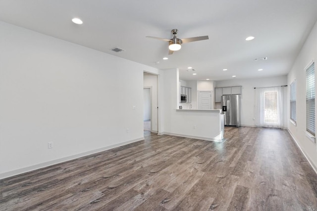 unfurnished living room featuring ceiling fan and wood-type flooring