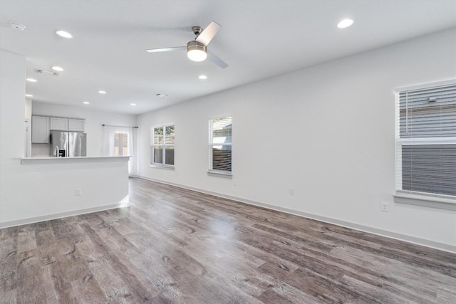 unfurnished living room with hardwood / wood-style flooring and ceiling fan