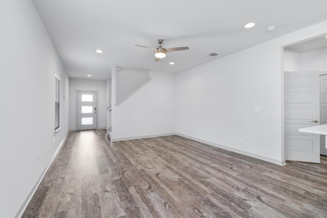 unfurnished living room with light wood-type flooring and ceiling fan