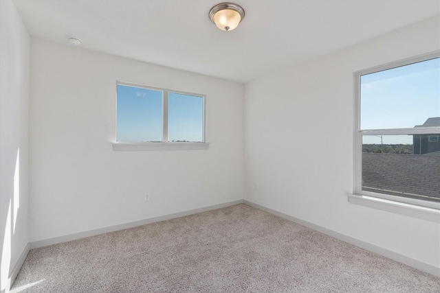 10400 Fulton Ave, Austin, TX 78754 - empty room featuring healthy amount of natural light, carpet floors, baseboards, and a smoke detector