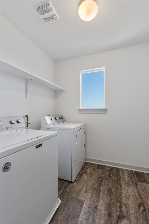 10400 Fulton Ave, Austin, TX 78754 - washroom with washer and dryer, dark wood-style flooring, and baseboards