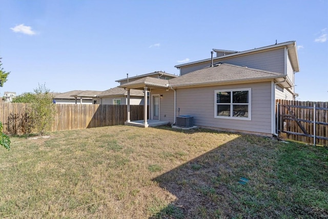 rear view of property featuring a yard and cooling unit