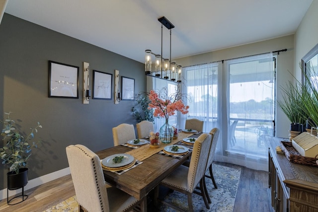 dining area with a notable chandelier, wood finished floors, and baseboards