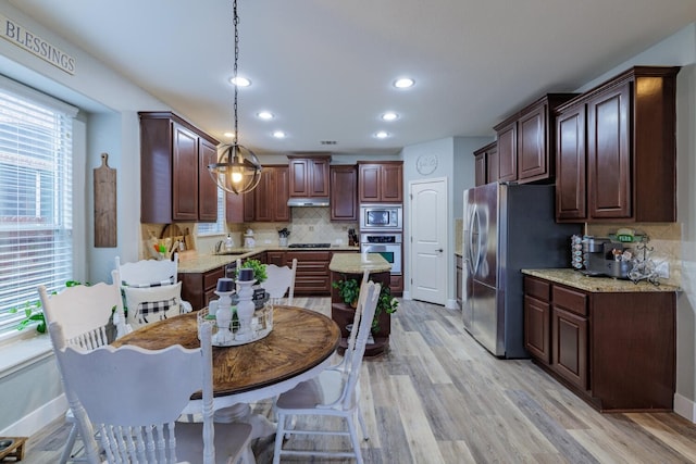 kitchen with tasteful backsplash, appliances with stainless steel finishes, light wood-type flooring, and a sink