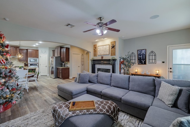 living room featuring ceiling fan and light hardwood / wood-style flooring