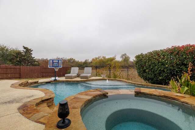 view of swimming pool featuring an in ground hot tub and pool water feature