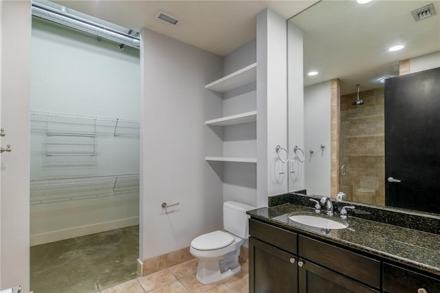 bathroom featuring tile patterned flooring, a shower with door, vanity, and toilet