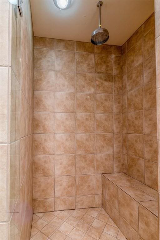 bathroom with tiled shower and tile patterned floors