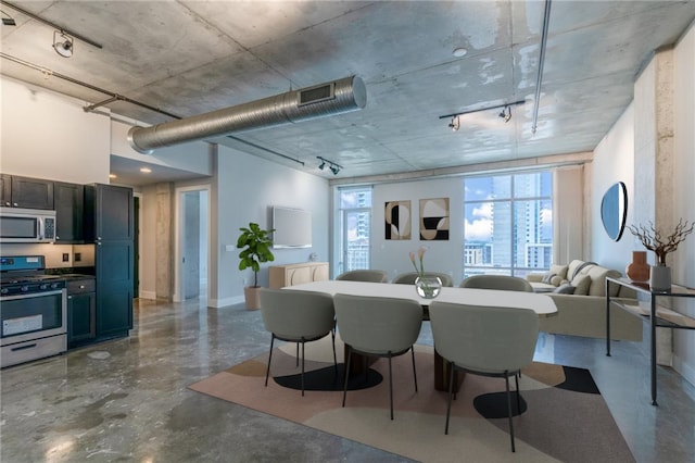 dining area featuring concrete flooring and rail lighting