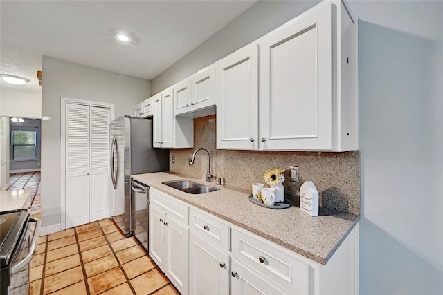 kitchen featuring white cabinets, backsplash, sink, and appliances with stainless steel finishes