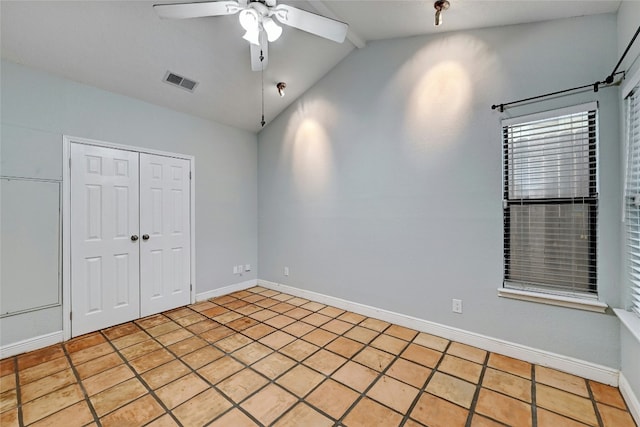 unfurnished bedroom with ceiling fan, a closet, light tile patterned flooring, and lofted ceiling