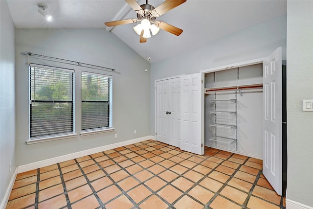 unfurnished bedroom with two closets, tile patterned floors, ceiling fan, and lofted ceiling