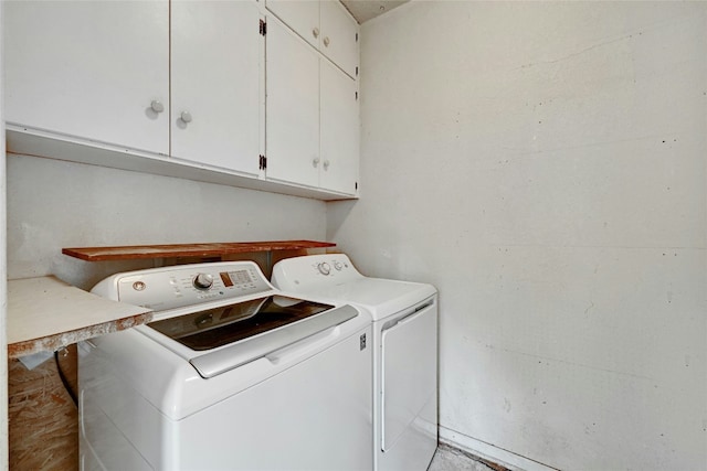 washroom featuring cabinets and washing machine and clothes dryer