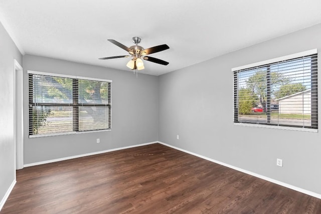 empty room with dark hardwood / wood-style floors, ceiling fan, and a healthy amount of sunlight