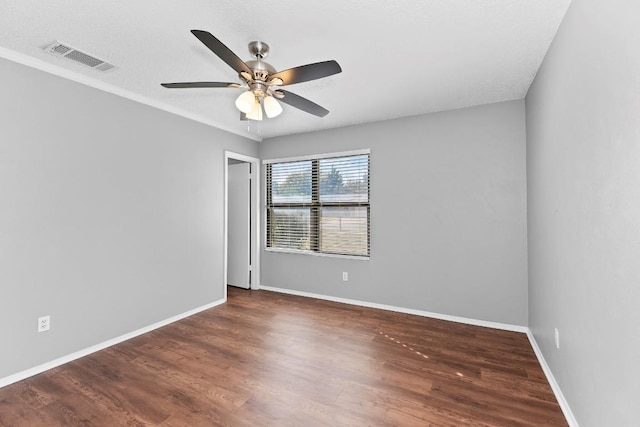 spare room with a textured ceiling, dark hardwood / wood-style floors, and ceiling fan