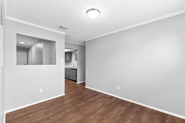 unfurnished room featuring a textured ceiling, crown molding, sink, and dark hardwood / wood-style floors