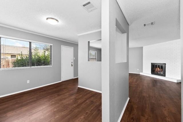 corridor with dark wood-type flooring, a textured ceiling, and ornamental molding