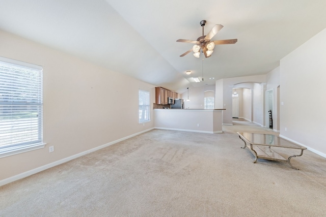 unfurnished living room featuring ceiling fan, light colored carpet, and vaulted ceiling