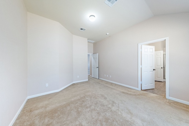 unfurnished bedroom featuring light colored carpet and lofted ceiling