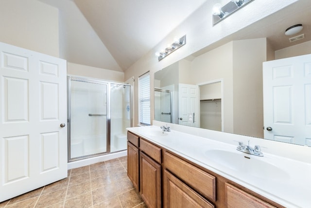 bathroom featuring tile patterned flooring, vanity, a shower with door, and lofted ceiling