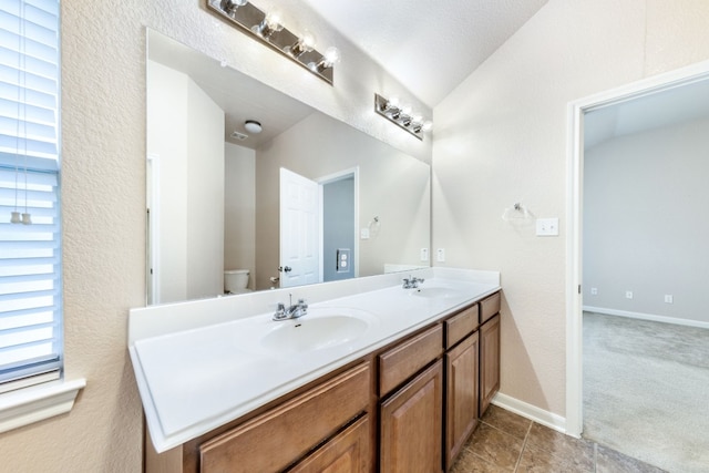 bathroom with tile patterned flooring, vanity, a textured ceiling, and toilet