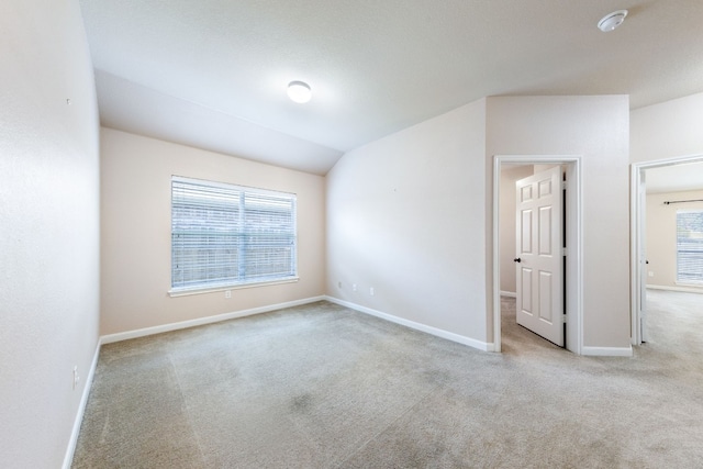 carpeted empty room featuring a healthy amount of sunlight and vaulted ceiling