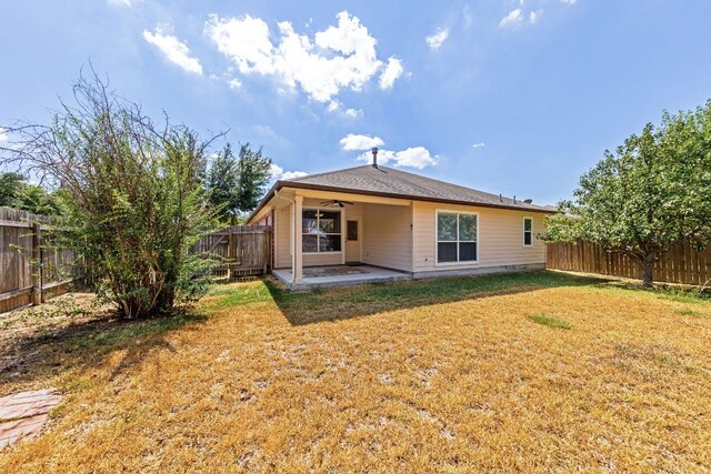 back of house featuring a lawn, ceiling fan, and a patio