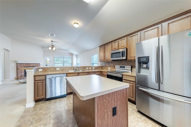 kitchen with kitchen peninsula, stainless steel appliances, sink, light tile patterned floors, and lofted ceiling