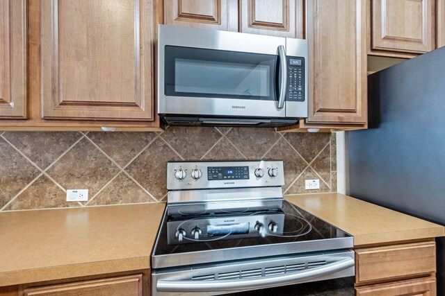 kitchen featuring stainless steel appliances and tasteful backsplash