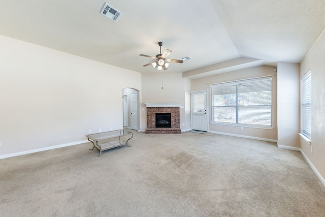 unfurnished living room featuring a fireplace, light colored carpet, ceiling fan, and lofted ceiling