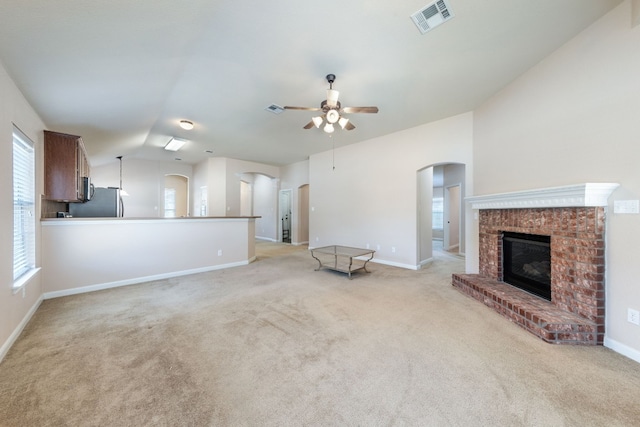 unfurnished living room with light carpet, a fireplace, ceiling fan, and lofted ceiling