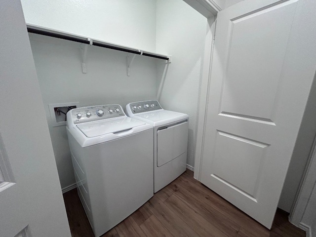 laundry area with washer and dryer and dark wood-type flooring