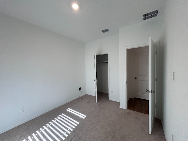 unfurnished bedroom featuring light carpet and a closet