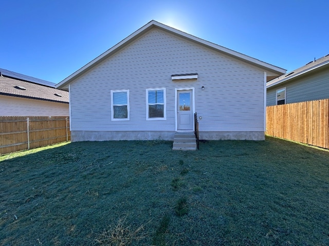 back of house featuring a lawn