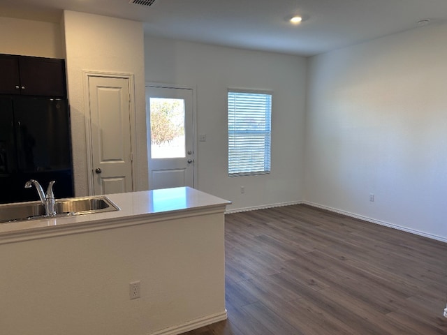 kitchen with black refrigerator, dark hardwood / wood-style flooring, and sink