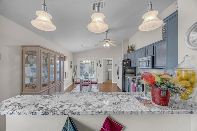 kitchen with kitchen peninsula, dark hardwood / wood-style floors, stainless steel appliances, and lofted ceiling