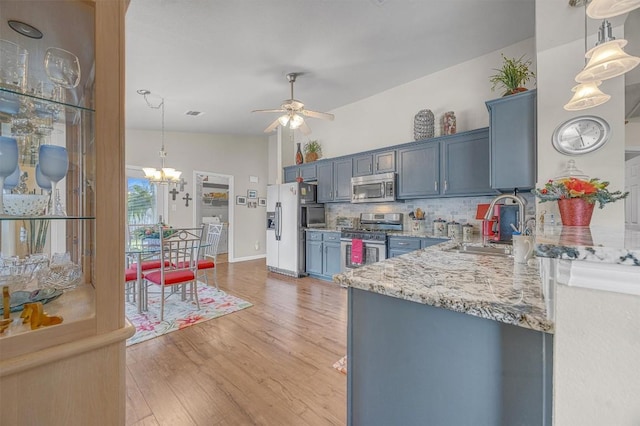 kitchen featuring appliances with stainless steel finishes, light wood-type flooring, tasteful backsplash, and blue cabinets